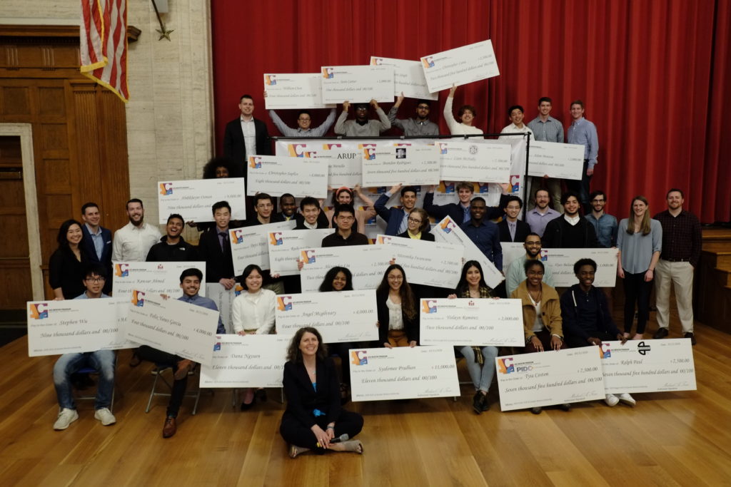 31 high school students pose with their mentors and giant scholarship checks